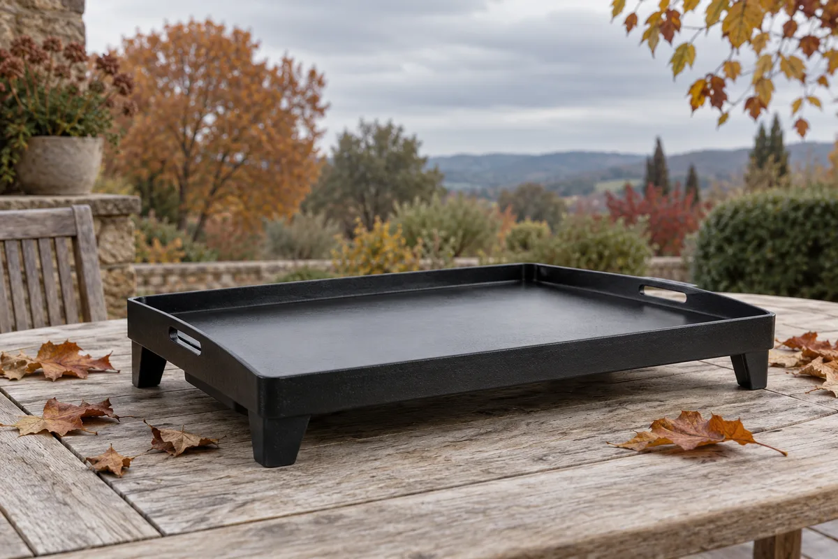 Plancha en fonte posée sur une table d&rsquo;extérieur sous un ciel d&rsquo;automne